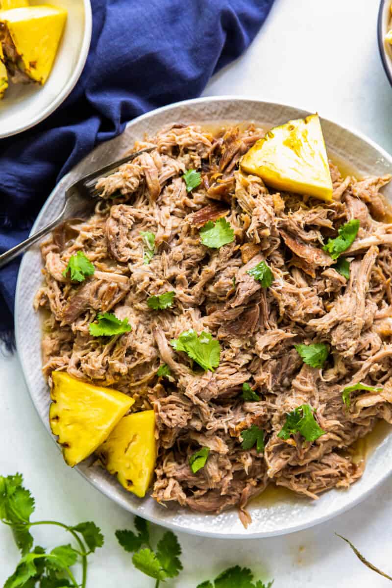 overhead plate of kalua pork on plate with pineapple slices