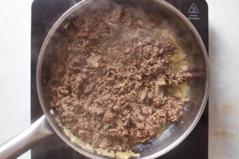 cooked ground beef in a stainless steel pan.