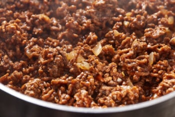 close up of ground beef in a stainless steel pan.