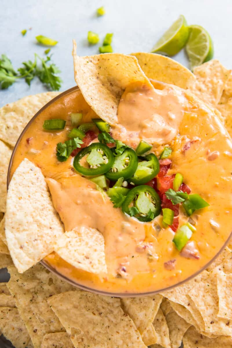 bowl of instant pot queso with chips and jalapenos