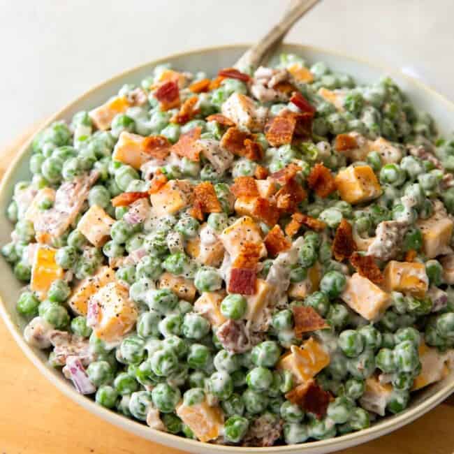 bowl of creamy pea salad topped with bacon