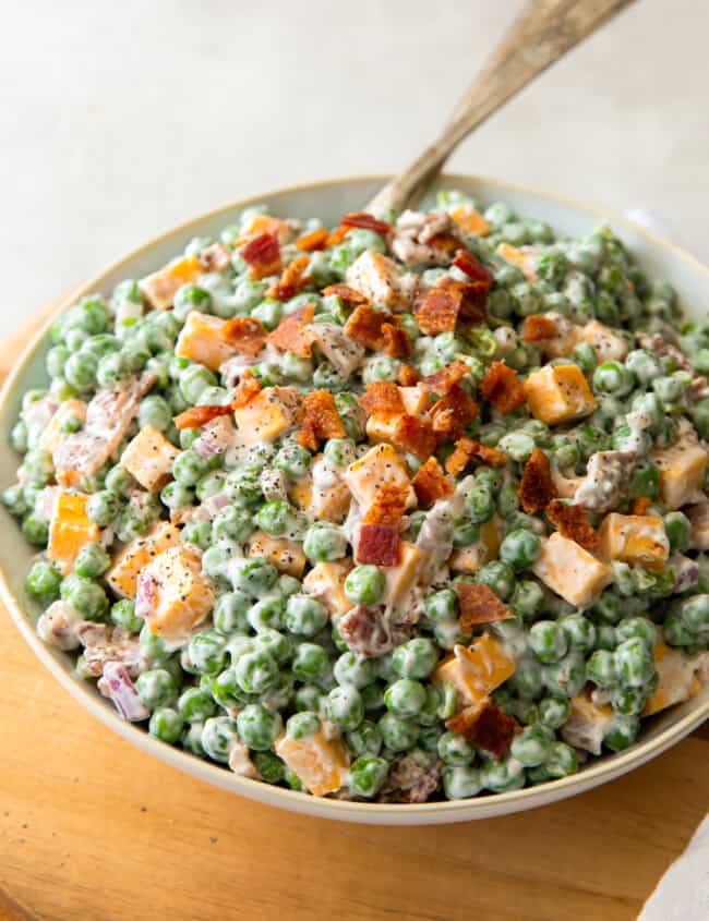 bowl of creamy pea salad topped with bacon