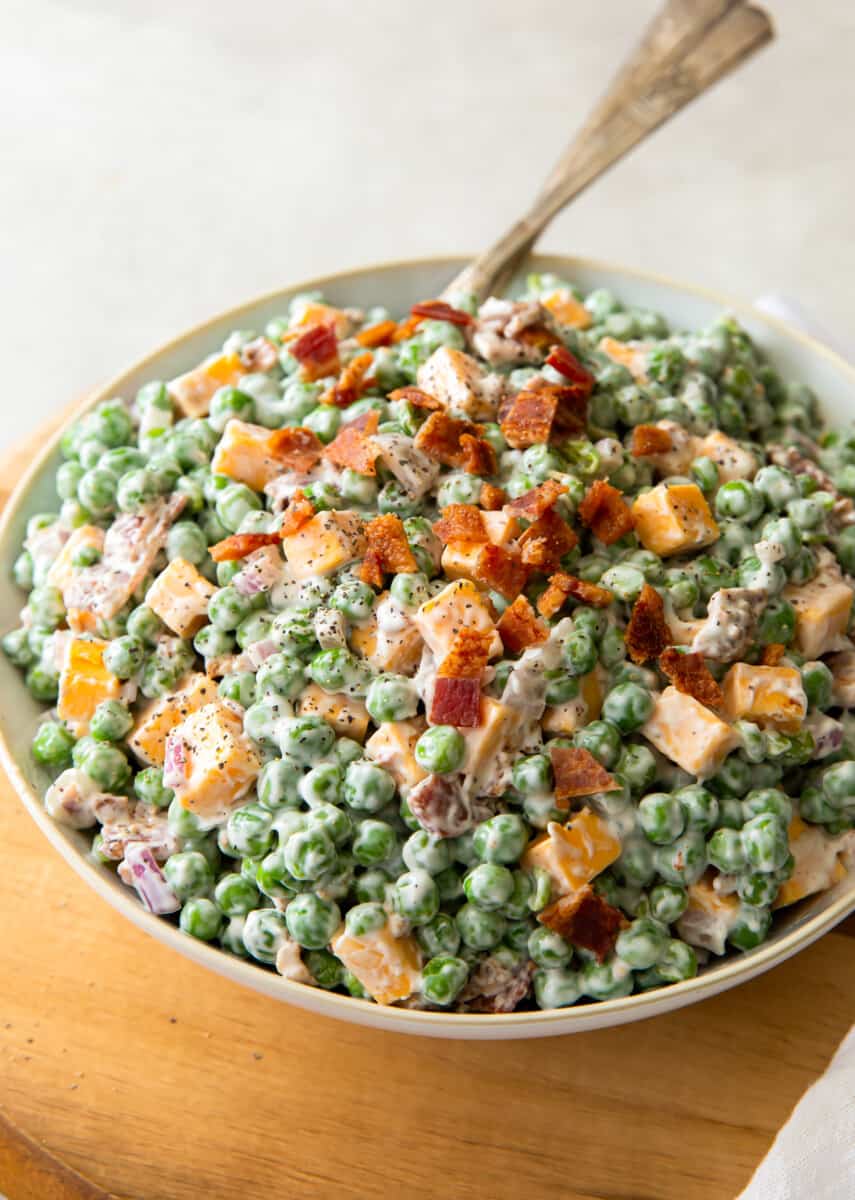 bowl of creamy pea salad topped with bacon