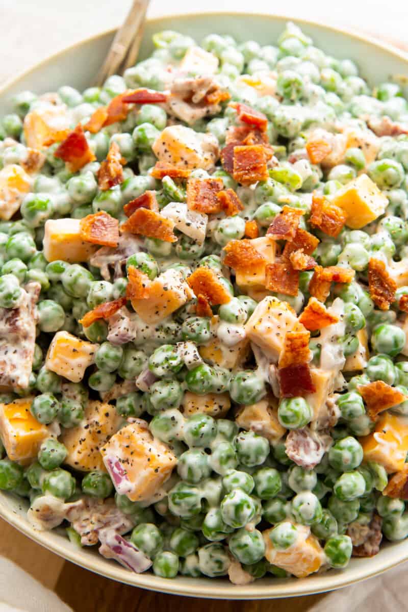 up close bowl of pea salad with cheese and bacon