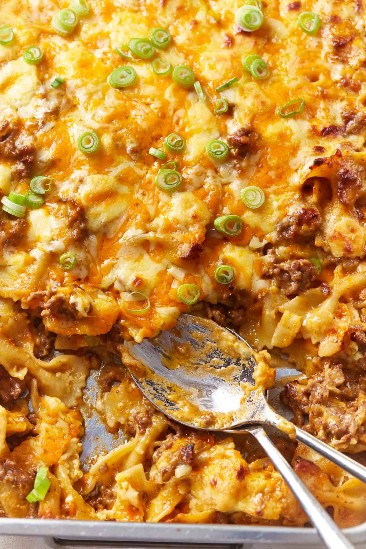 sloppy joe casserole in a baking pan with spoons.