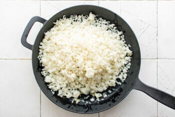cauliflower rice in a cast iron pan.