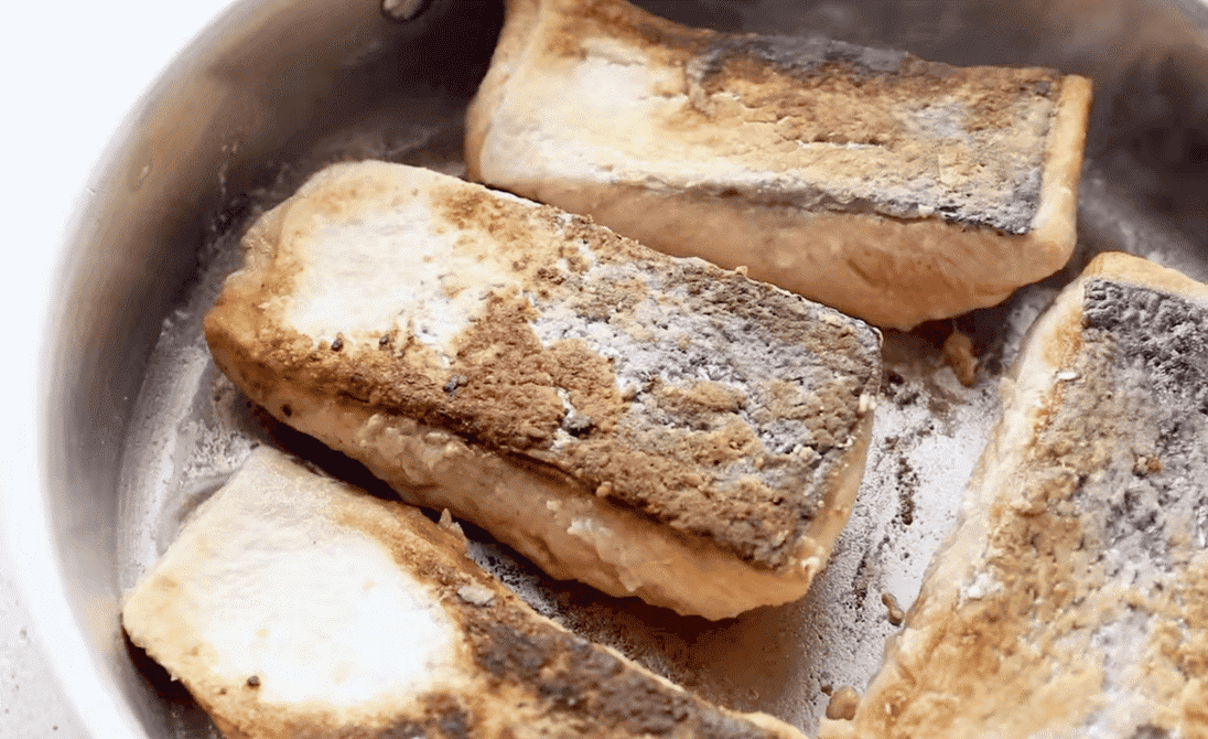 Searing the salmon in a skillet. 