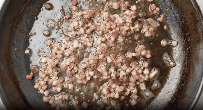 diced pancetta cooking in a skillet.