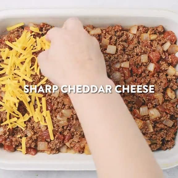 Layering cheese over the beans and meat. 