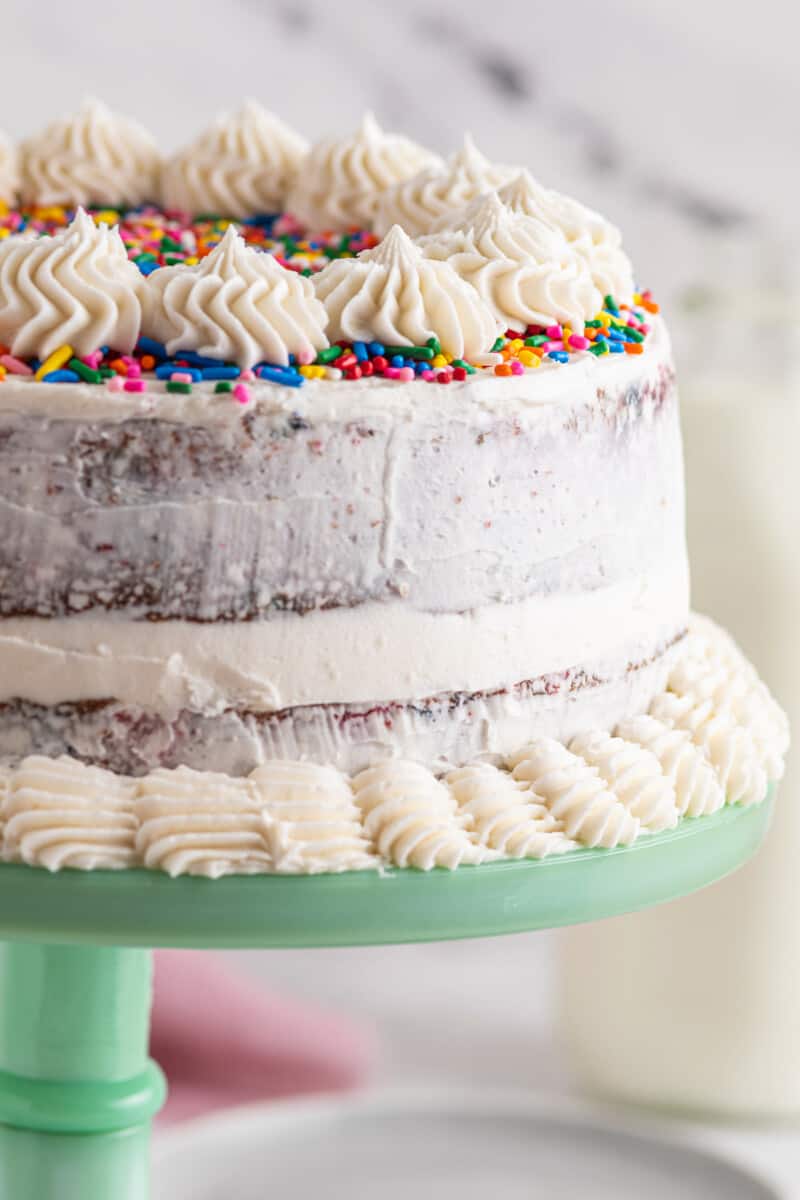 frosted funfetti cake on green cake stand