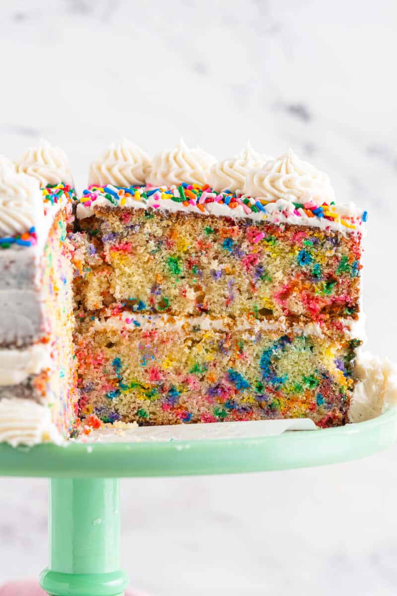 inside of frosted funfetti cake on green cake stand