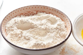 seasoned flour in a white and red bowl.