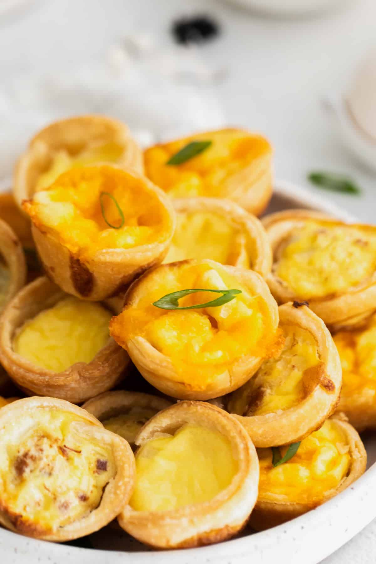 close up of mini quiches on a white plate.