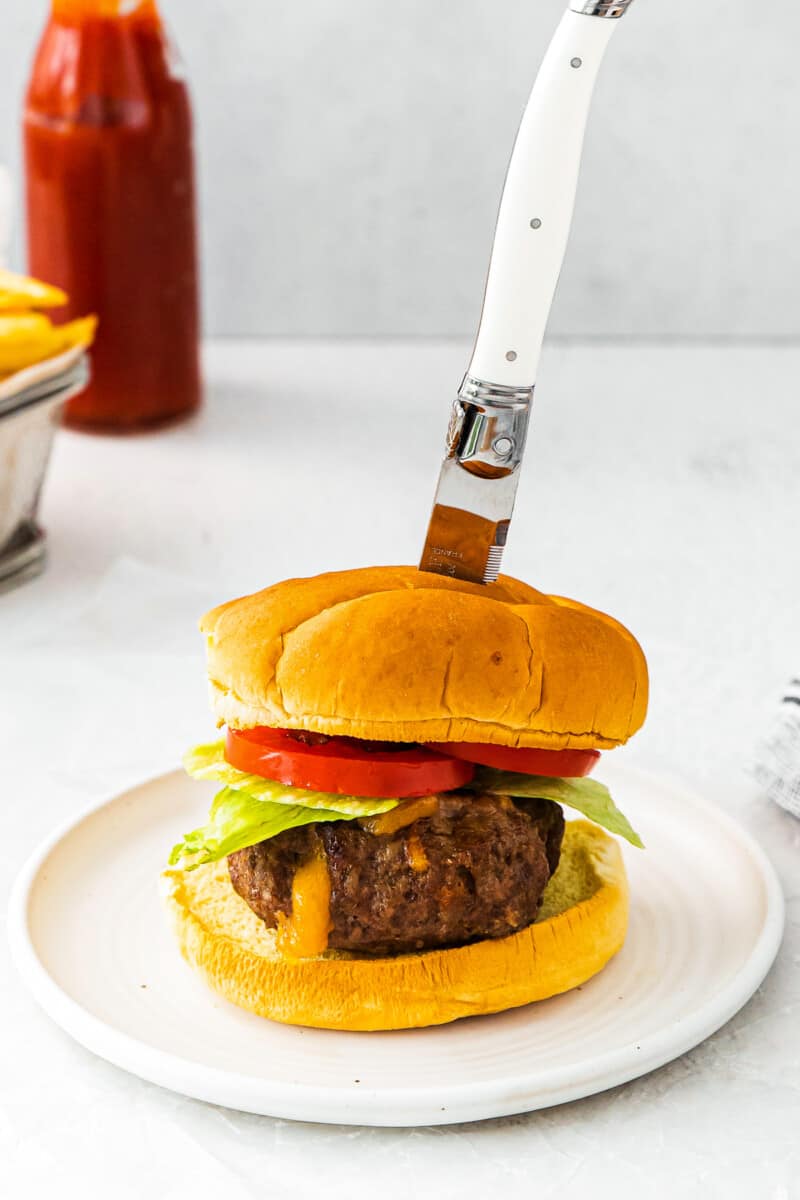 knife in air fryer juicy lucy burger on white table