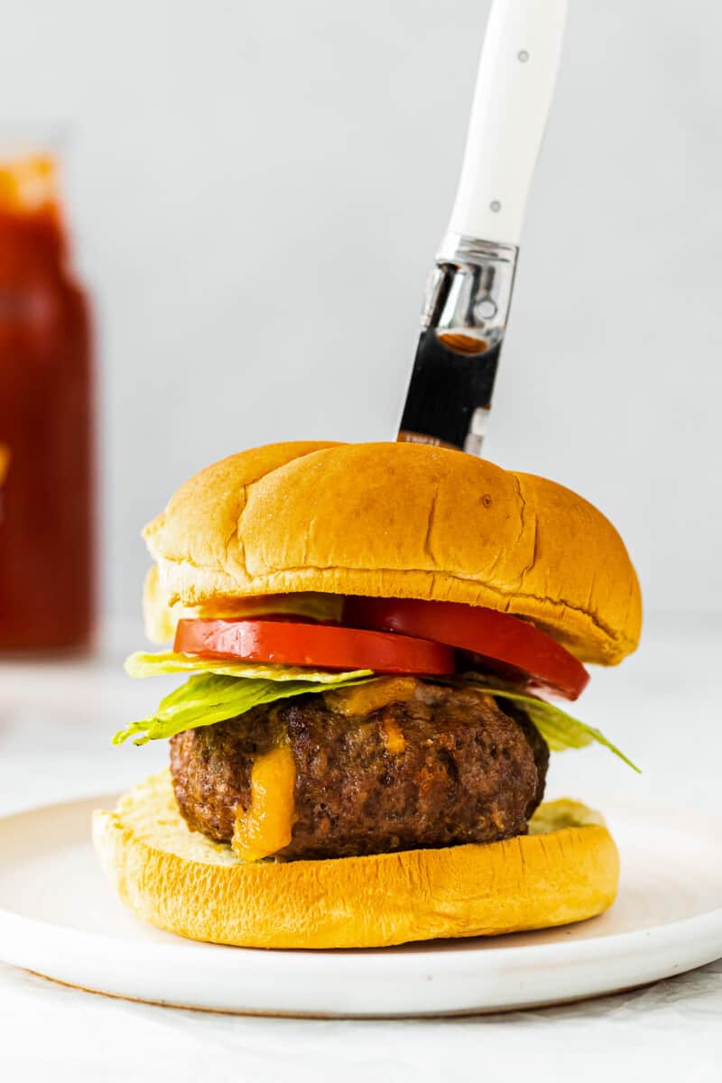 knife in air fryer juicy lucy burger on white table