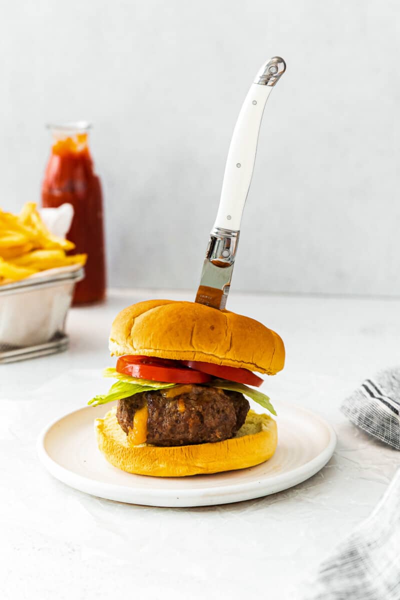 knife in air fryer juicy lucy burger on white table