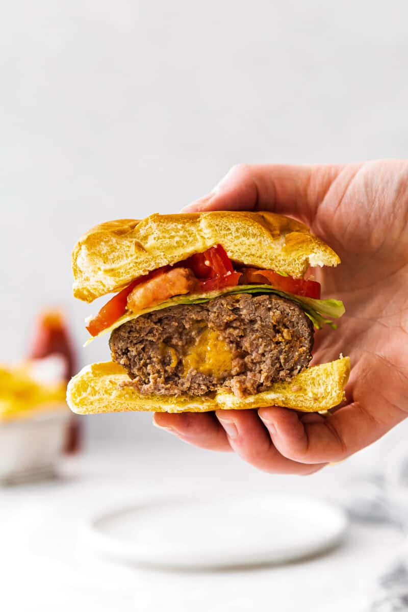 holding up half of air fryer juicy lucy burger