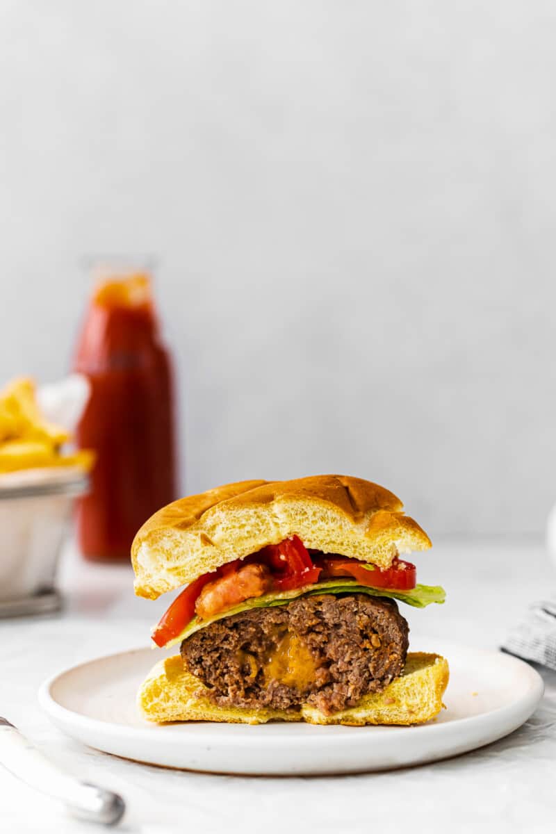 half of juicy lucy burger showing cheesy inside