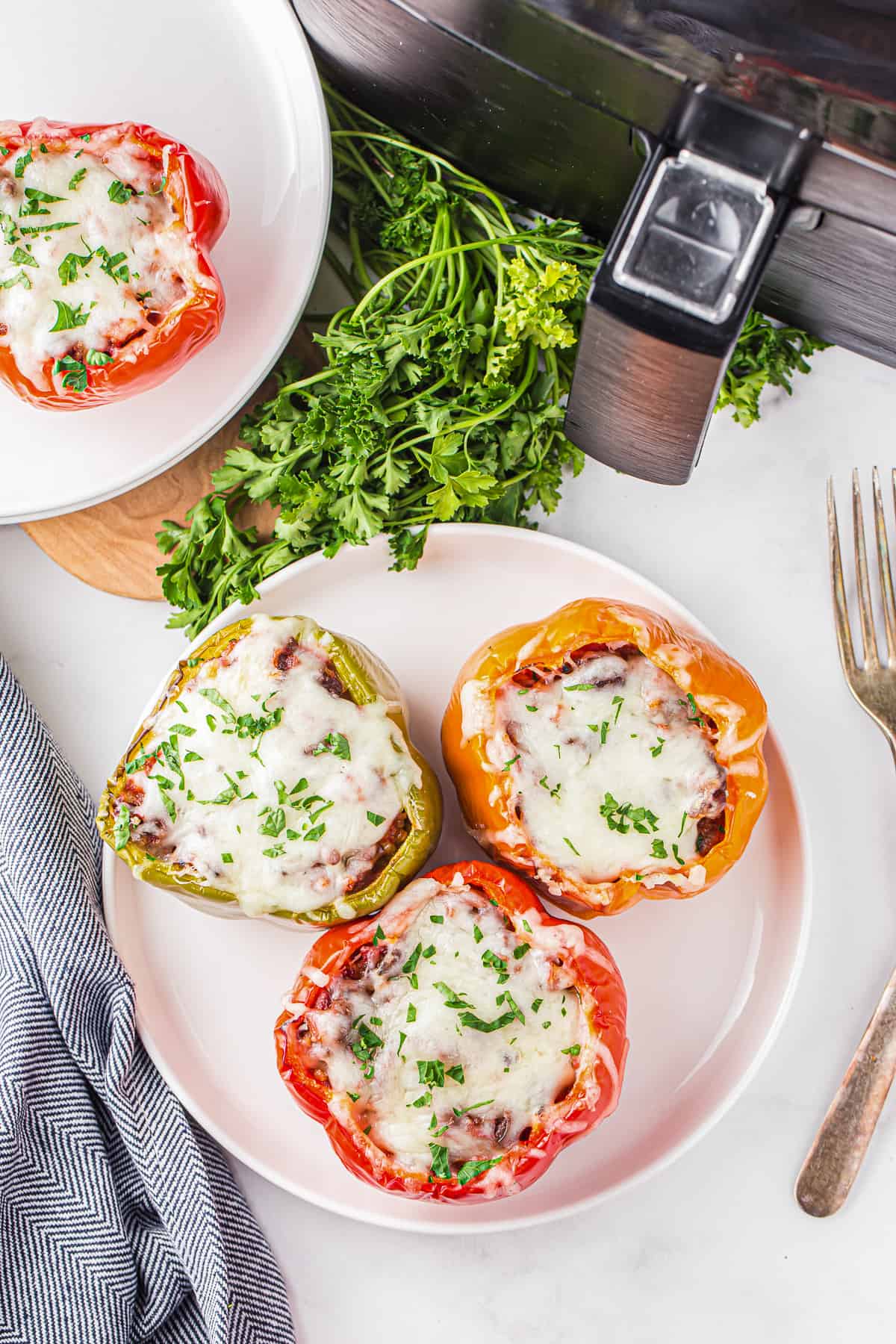 a plate of stuffed peppers next to an air fryer