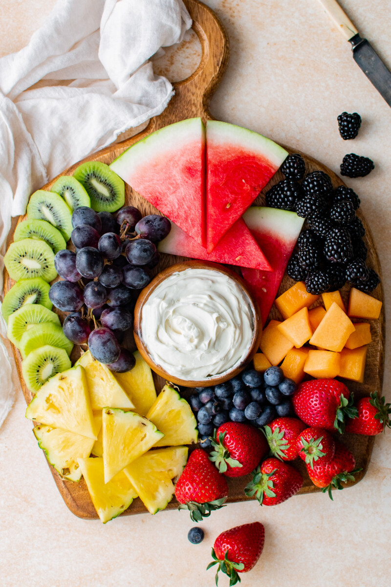 fruit board with cream cheese fruit dip in the middle