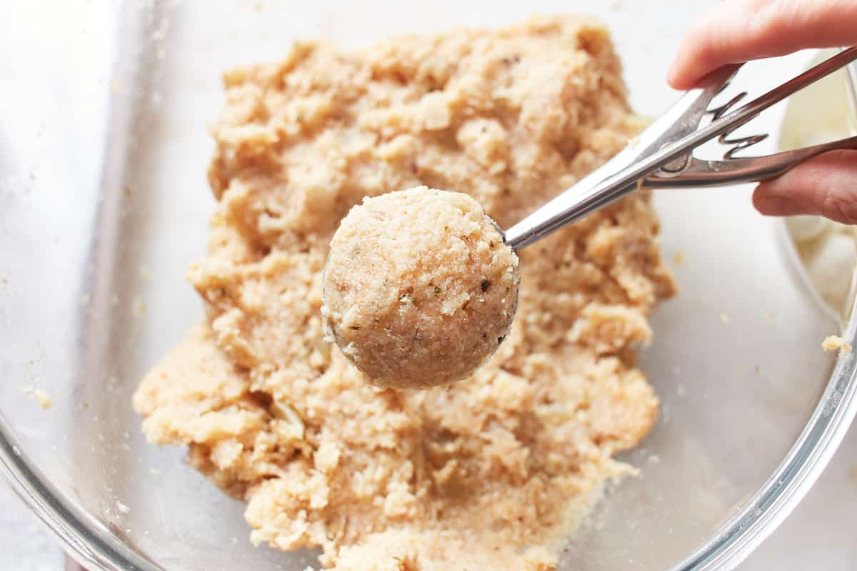 A rounded stuffed turkey meatball in a cookie portion scoop.
