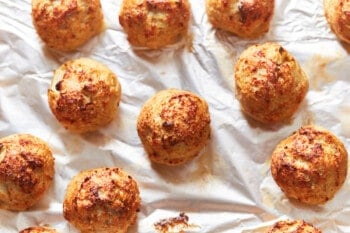 close up of baked turkey meatballs on a baking sheet.