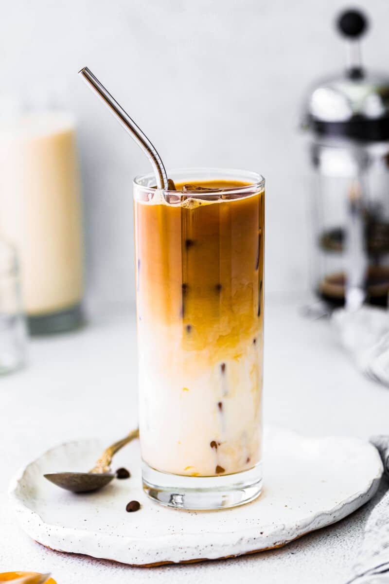iced caramel macchiato in glass with metal straw