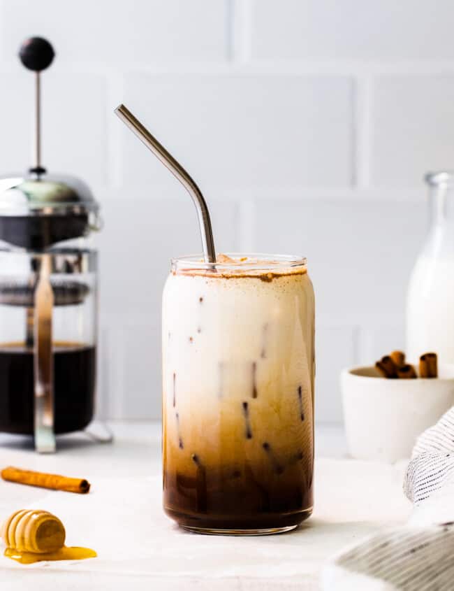 glass of iced honey cinnamon latte with metal straw