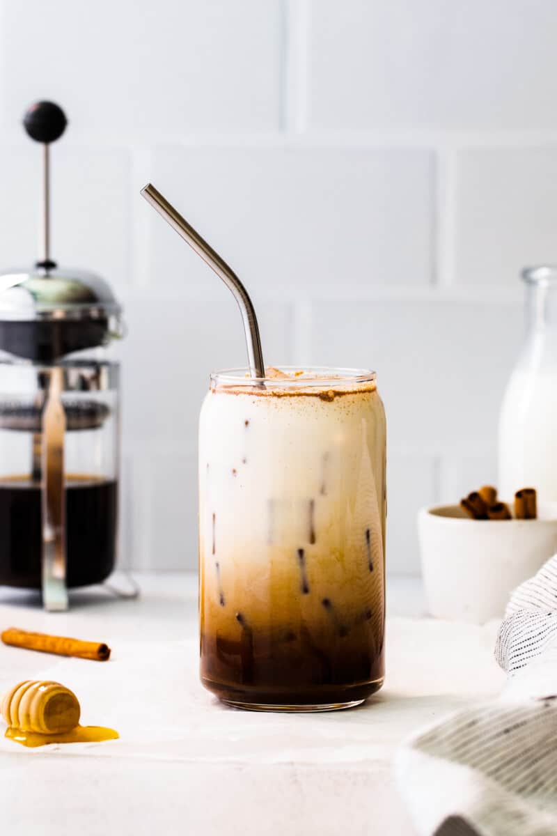 glass of iced honey cinnamon latte with metal straw