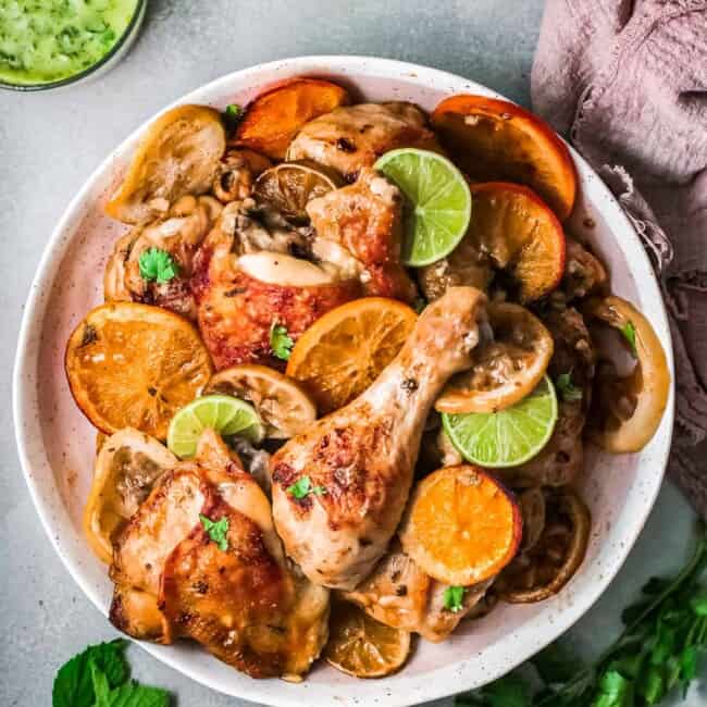 cuban mojo chicken on white plate with citrus slices