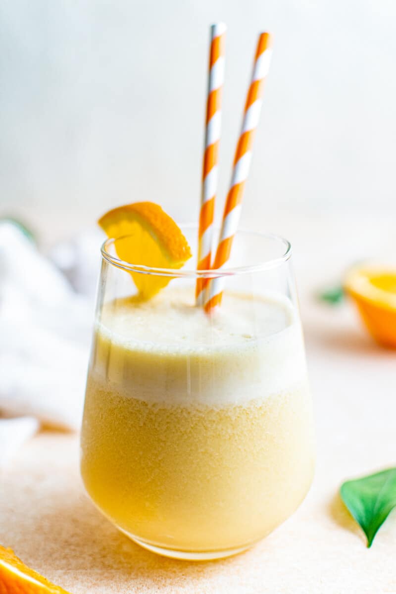 two striped straws in glass of orange julius
