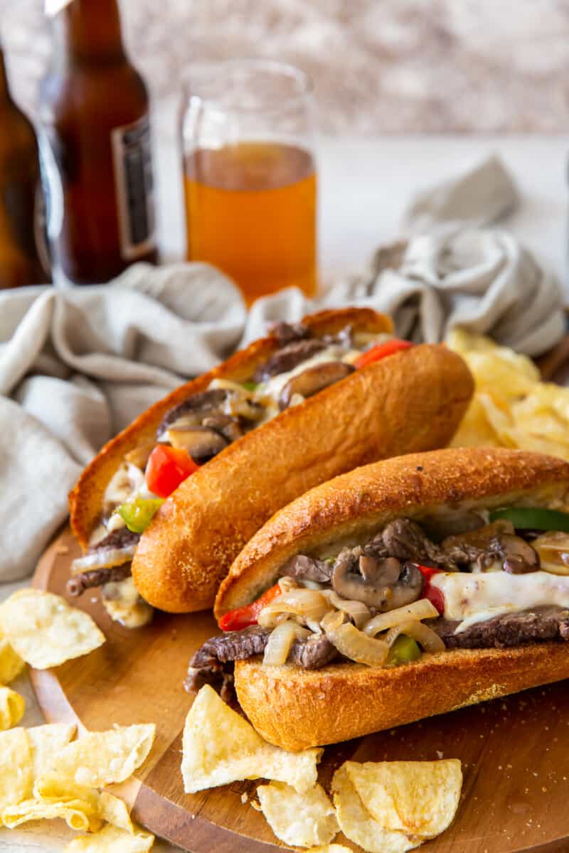 two philly cheesesteaks on cutting board