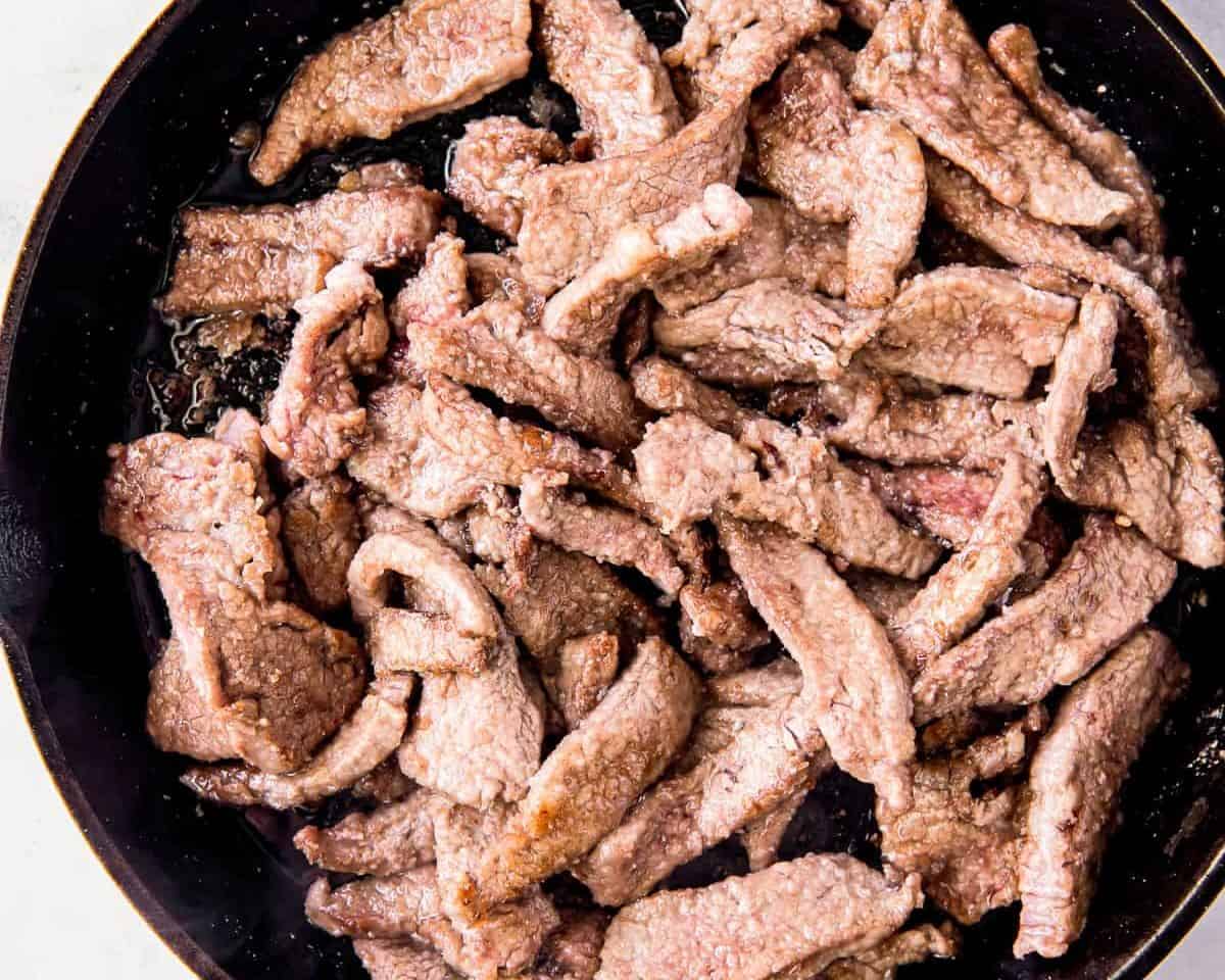 Strips of beef in a skillet.
