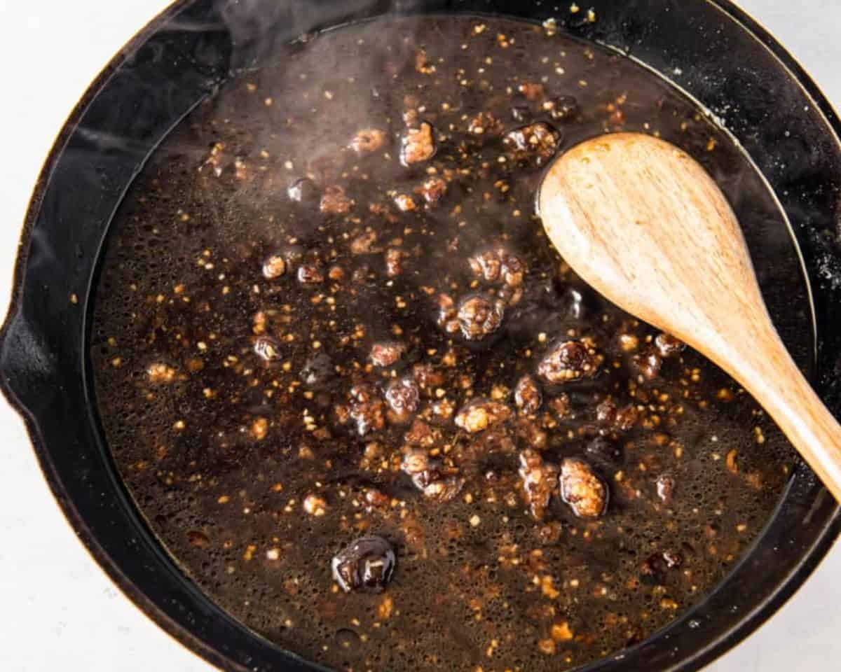 Stirring the sauce with a wooden spoon.