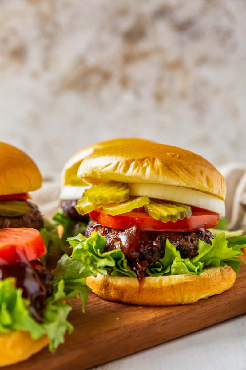 grilled bbq burgers with lettuce, tomato, onion, and pickles