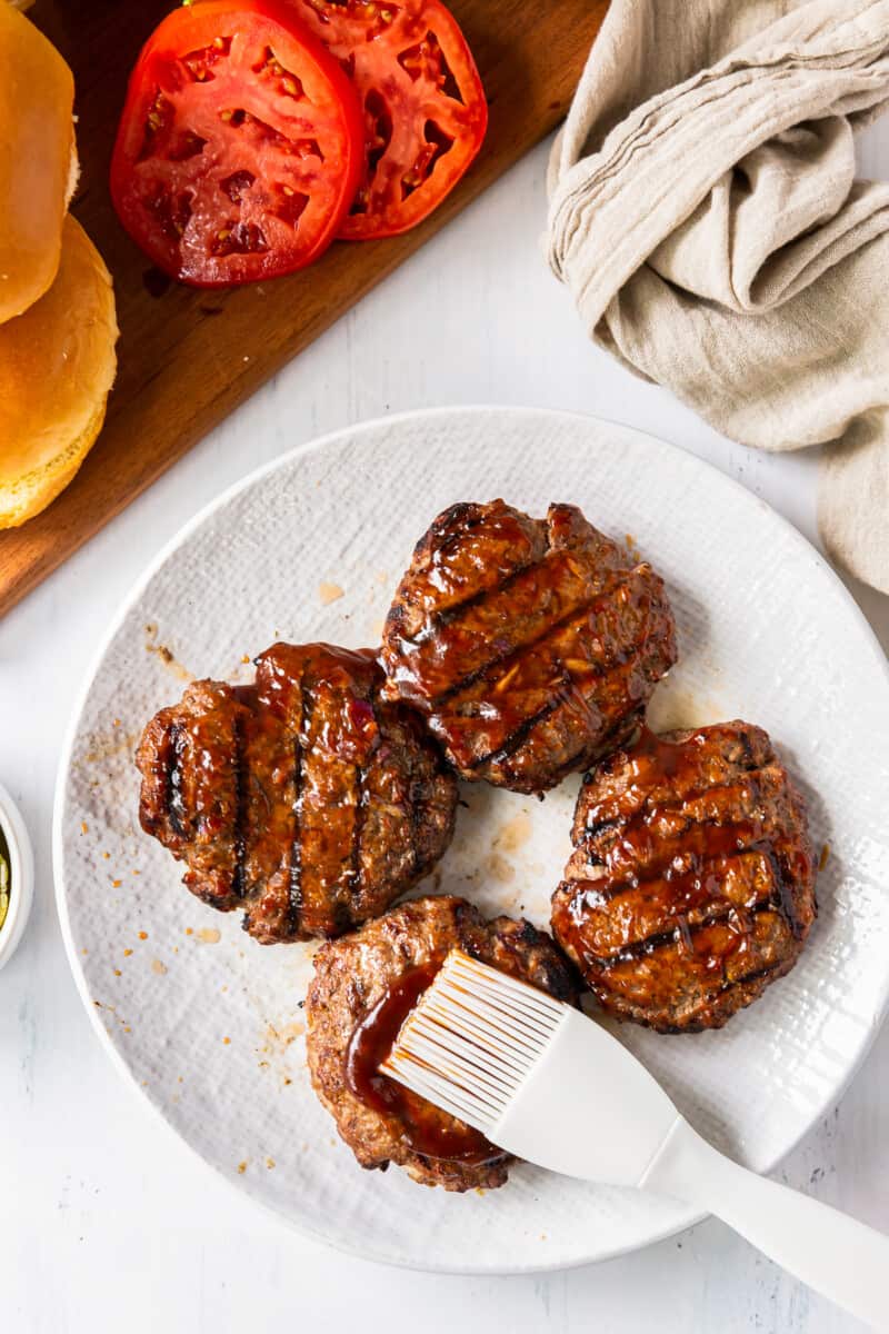 brushing bbq sauce on burgers