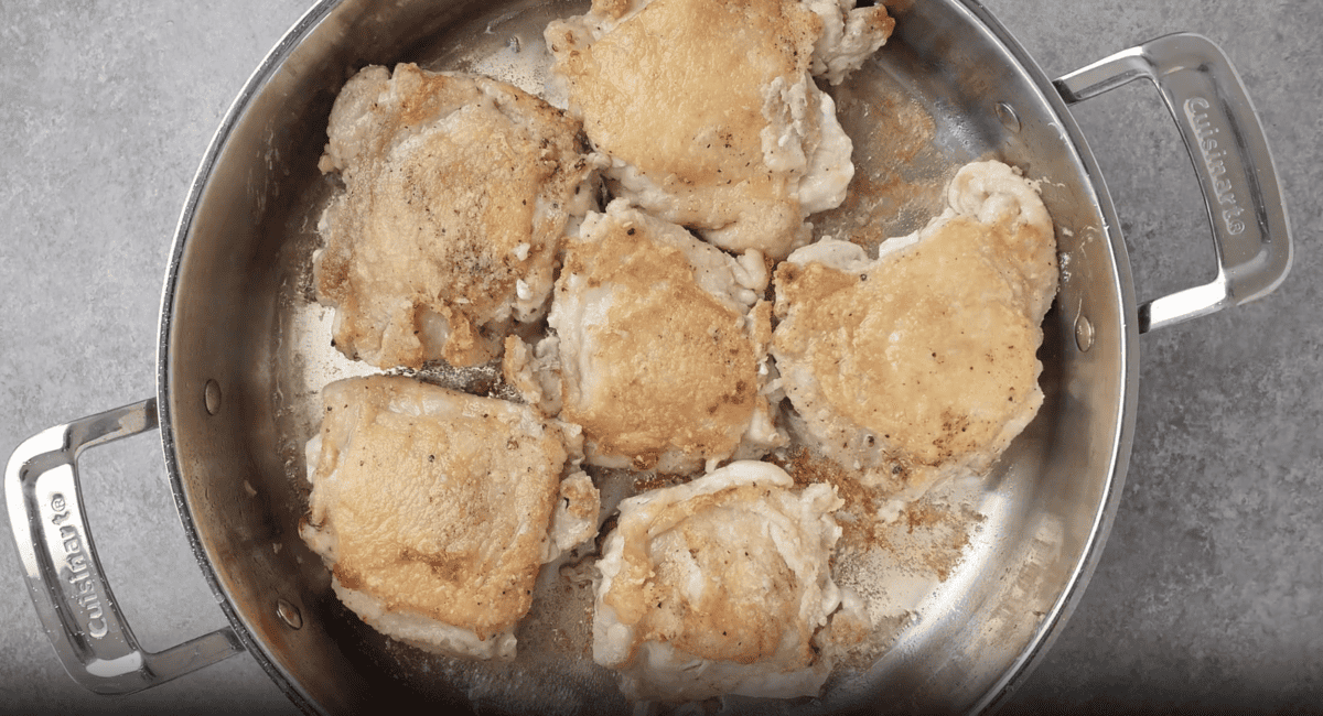 seared chicken thighs in a pan.