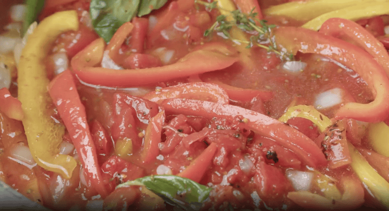 saucy tomatoes and peppers in a pan.