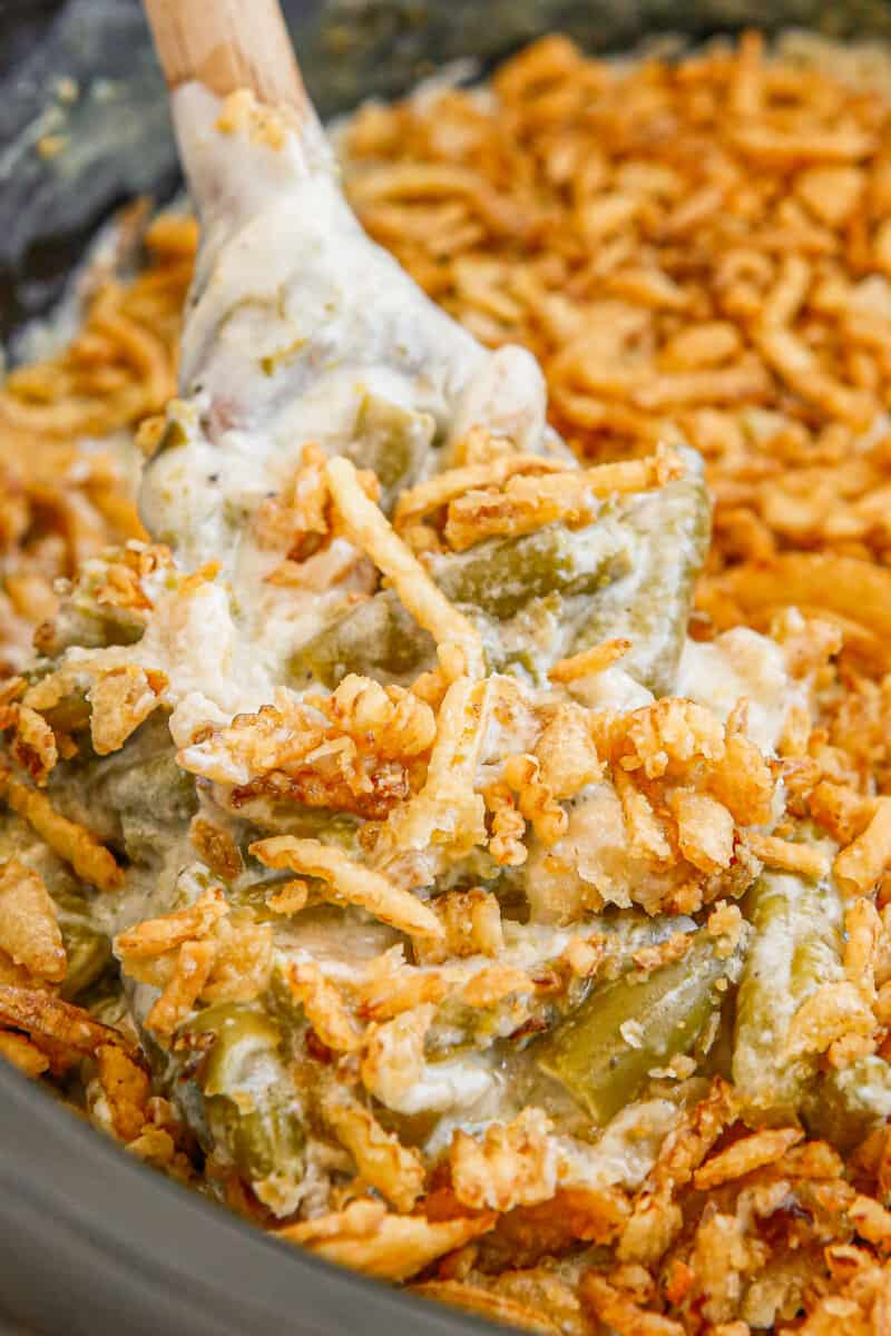 up close wooden spoon in crockpot green bean casserole