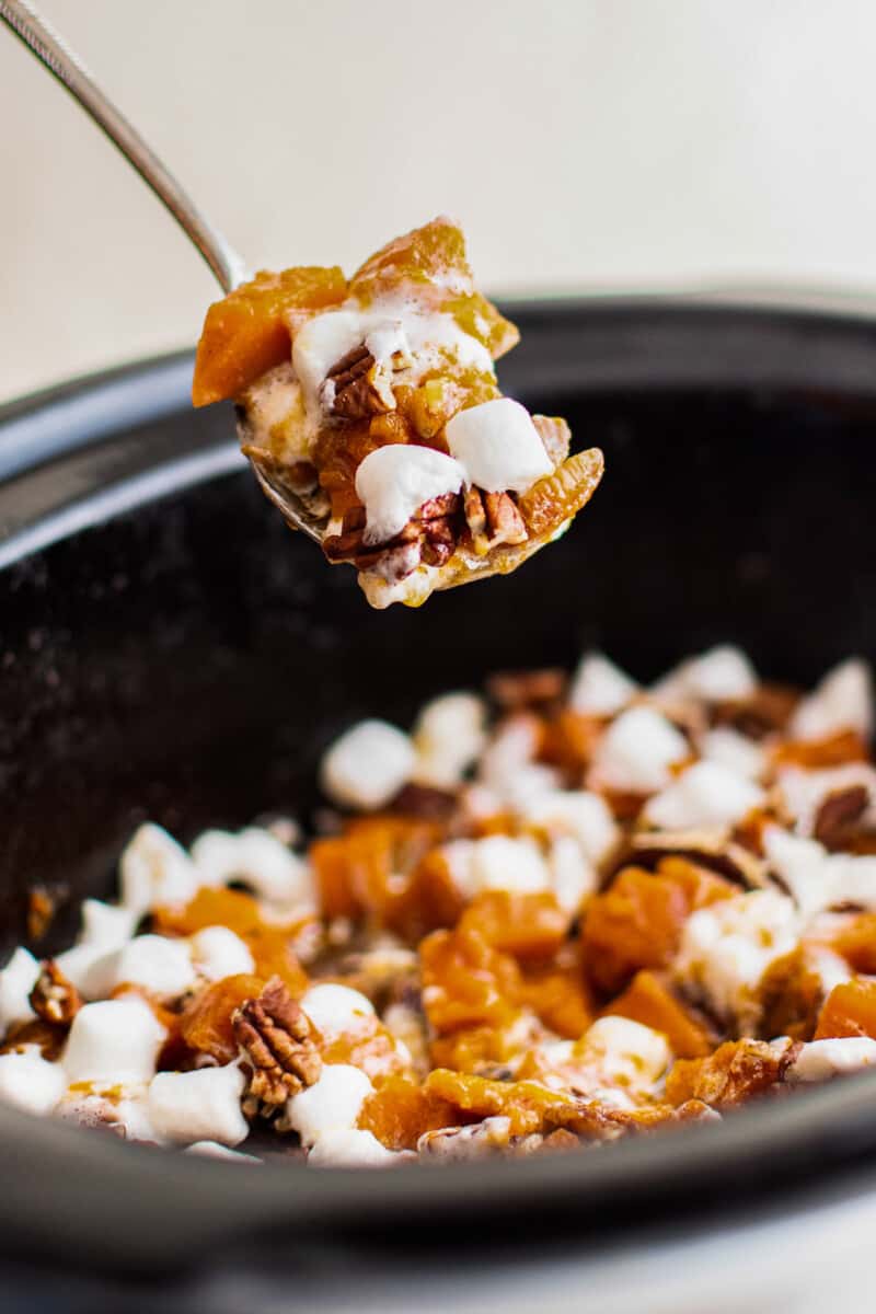 lifting up forkful of sweet potato casserole from crockpot