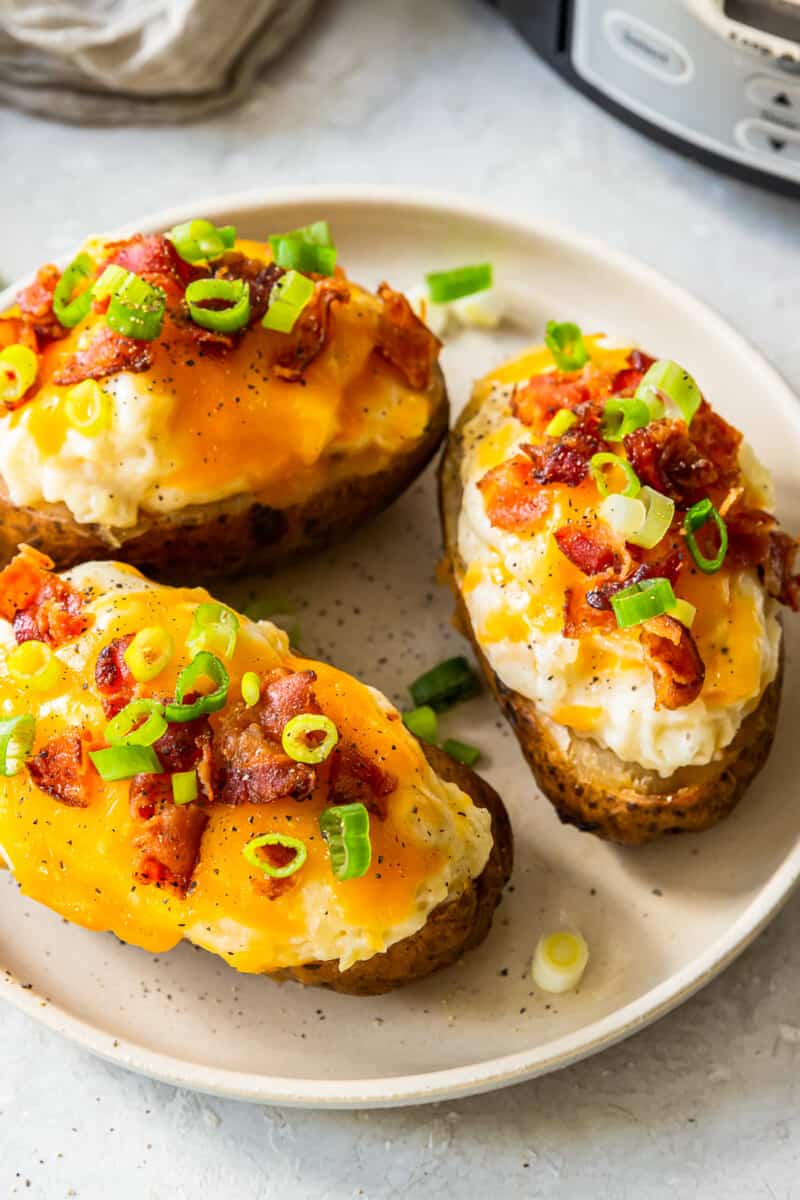 three crockpot twice baked potatoes on white plate