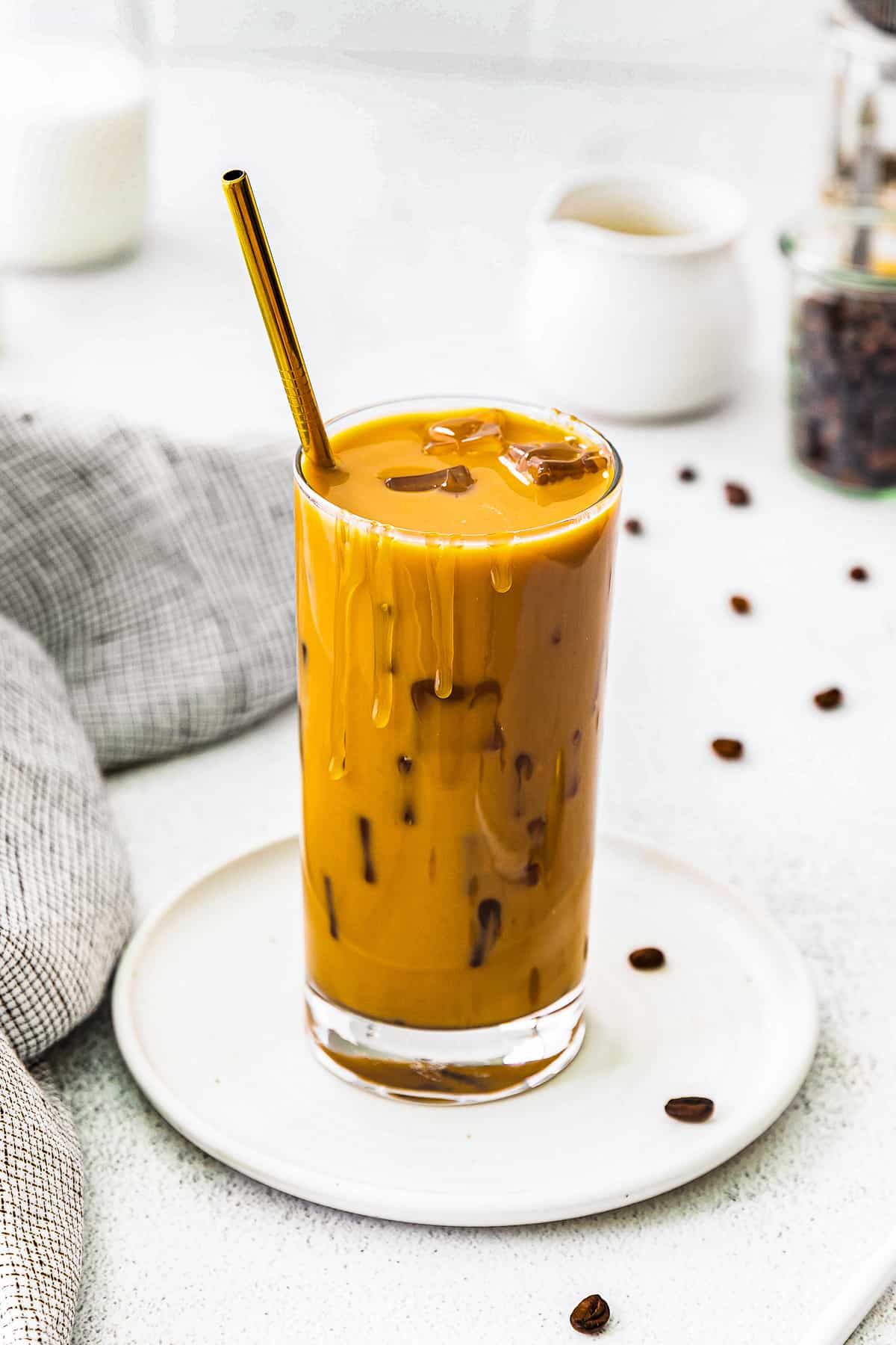 stirred iced caramel latte in glass with gold straw