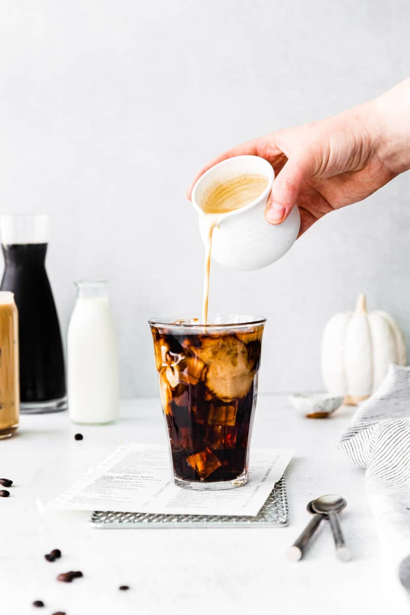 pouring pumpkin cream into pumpkin cream cold brew