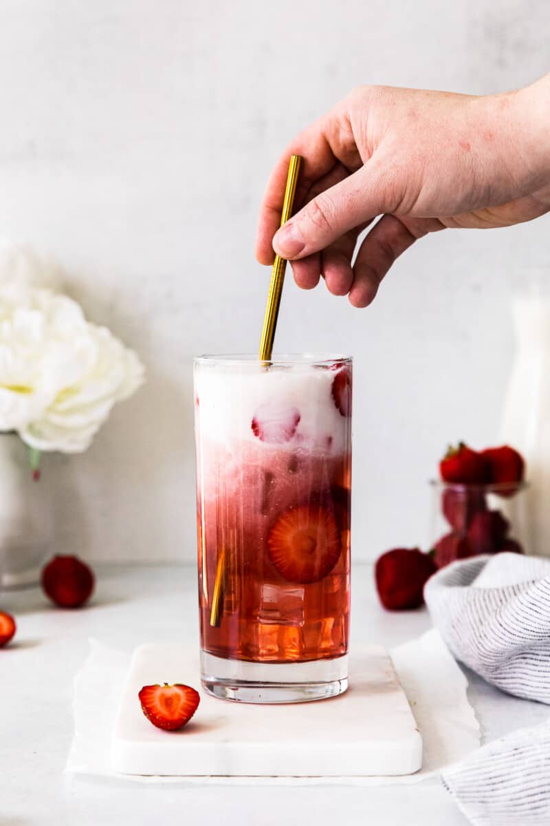 stirring cream into strawberry pink drink