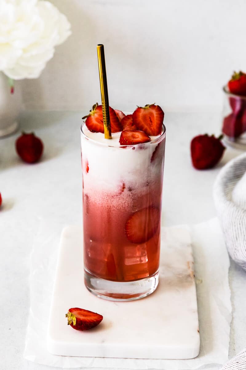 strawberry pink drink topped with sliced strawberries