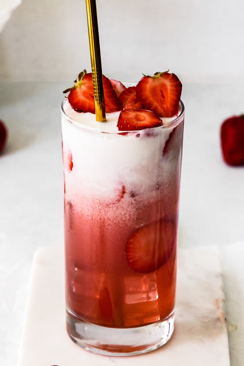 strawberry pink drink topped with sliced strawberries