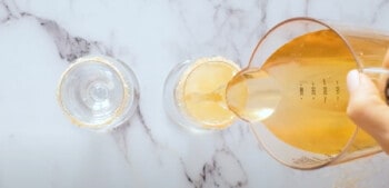 pouring apple cider into a champagne glass
