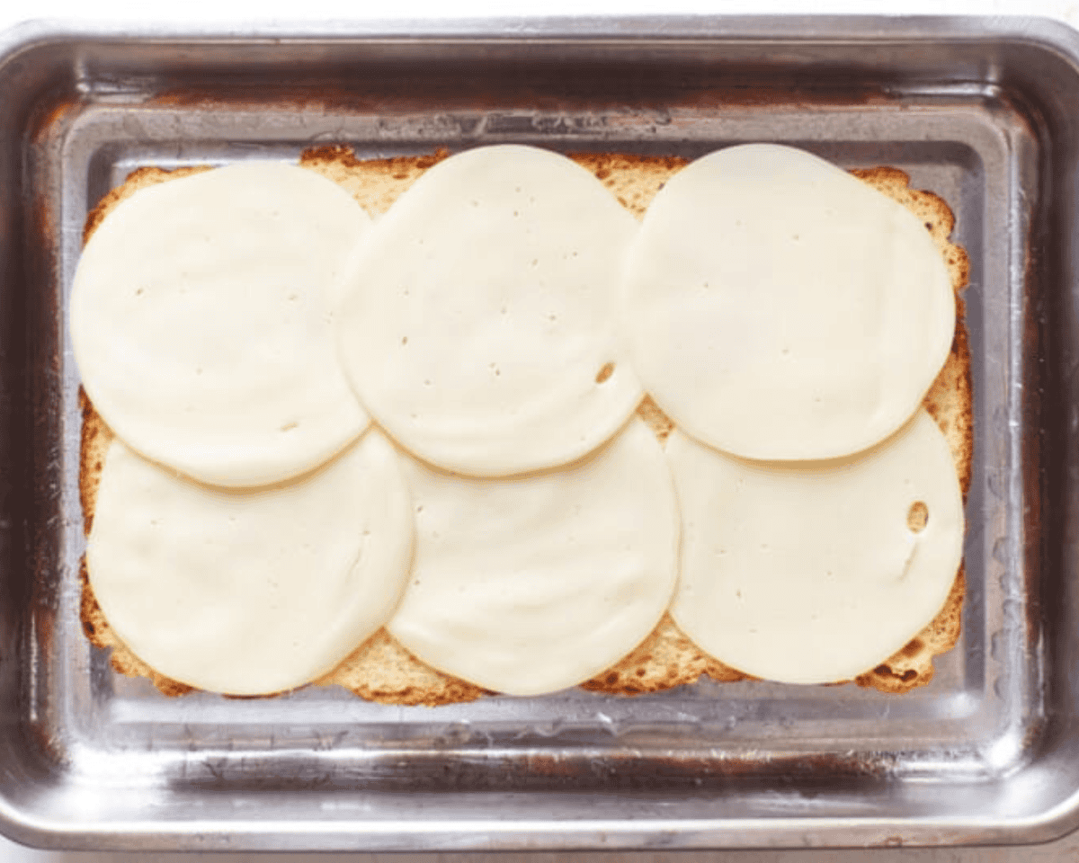 Slider buns topped with cheese.