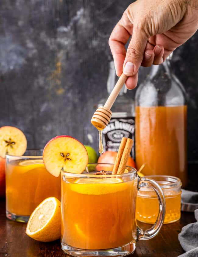 pouring honey into apple cider hot toddy