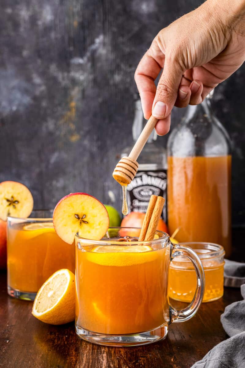 pouring honey into apple cider hot toddy
